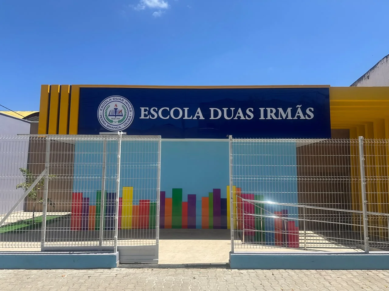 Vista frontal da entrada da Escola Duas Irmãs com o nome da escola em destaque